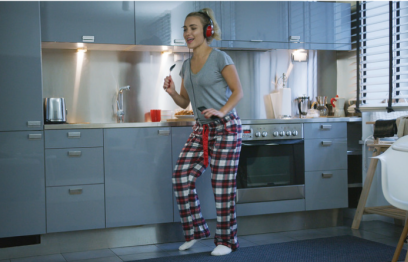 Woman singing and dancing in her kitchen.