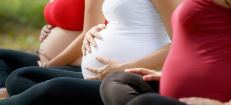 Image of three pregnant women holding their bellies.